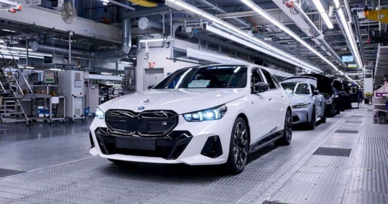 BMW i5 electric sedan on the production line at BMW's manufacturing facility, showcasing the company's commitment to electric vehicle production.