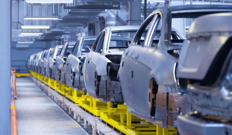 Vehicle body shells on an automated assembly line in a modern automotive manufacturing plant, showcasing Thailand's advanced production capabilities.