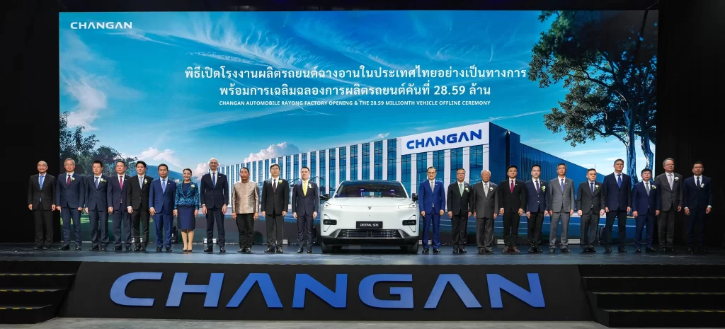 Changan Automobile Rayong Factory opening ceremony in Thailand with executives and officials standing on stage with a white Changan electric vehicle and factory image backdrop