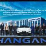 Changan Automobile Rayong Factory opening ceremony in Thailand with executives and officials standing on stage with a white Changan electric vehicle and factory image backdrop