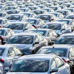 Rows of new dark-colored sedans arranged in a vehicle storage lot, representing Vietnam's expanding automotive market in 2025