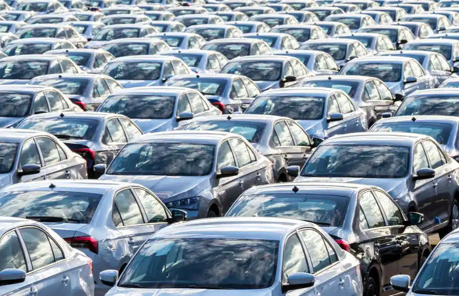 Rows of new dark-colored sedans arranged in a vehicle storage lot, representing Vietnam's expanding automotive market in 2025