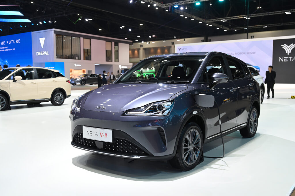 NETA’s Troubles in Thailand: What It Means for Consumers and the Automotive Industry 1 A NETA V-II electric city car on display at an auto show, plugged in for charging